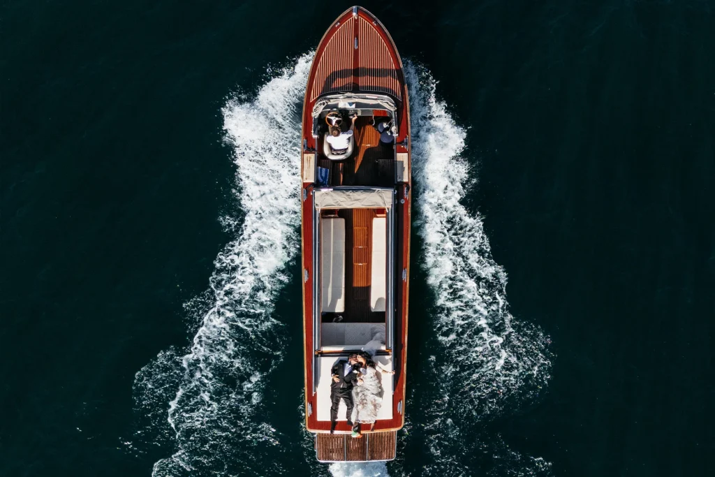 Couple relaxing on sunbed during a Lake Como boat photoshooting, aerial drone view