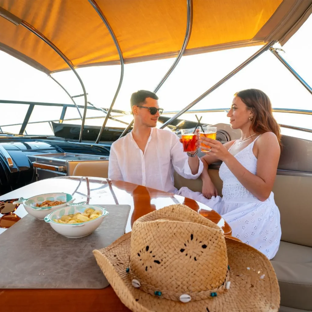 Primo piano di una coppia che si gode un drink sul Riva Rivale 52 sul Lago di Como durante un tour privato in barca
