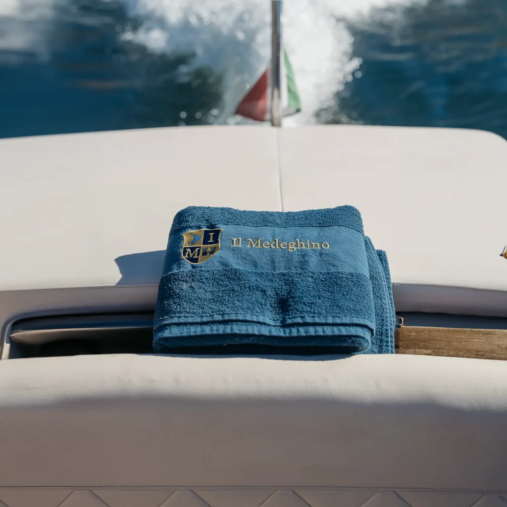 Sun deck of Il Medeghino water taxi with personalized towel on Lake Como