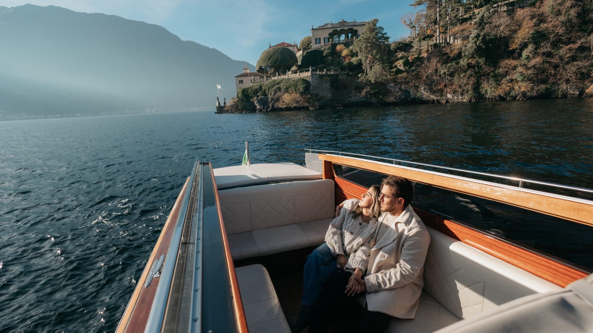 Couple embracing on a taxi boat during a private tour photoshoot on Lake Como