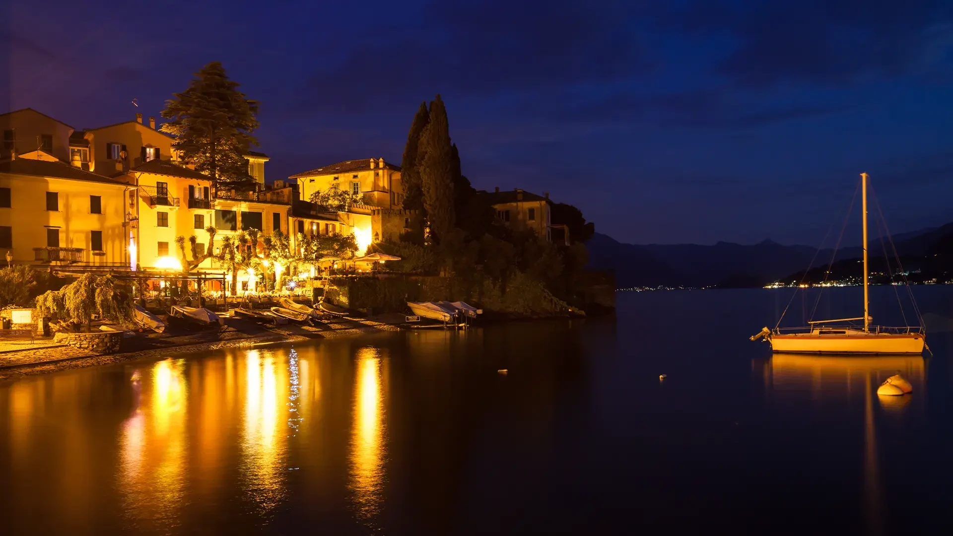 Illuminated lakeside village at night during a Lake Como dinner cruise