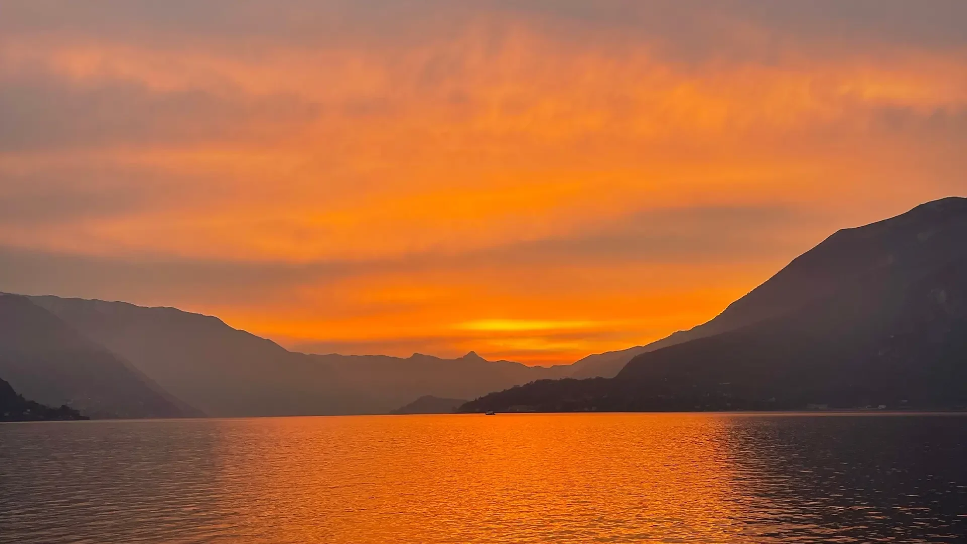 Kreuzfahrt bei Sonnenuntergang auf dem Comer See mit goldenen Reflexen auf dem Wasser