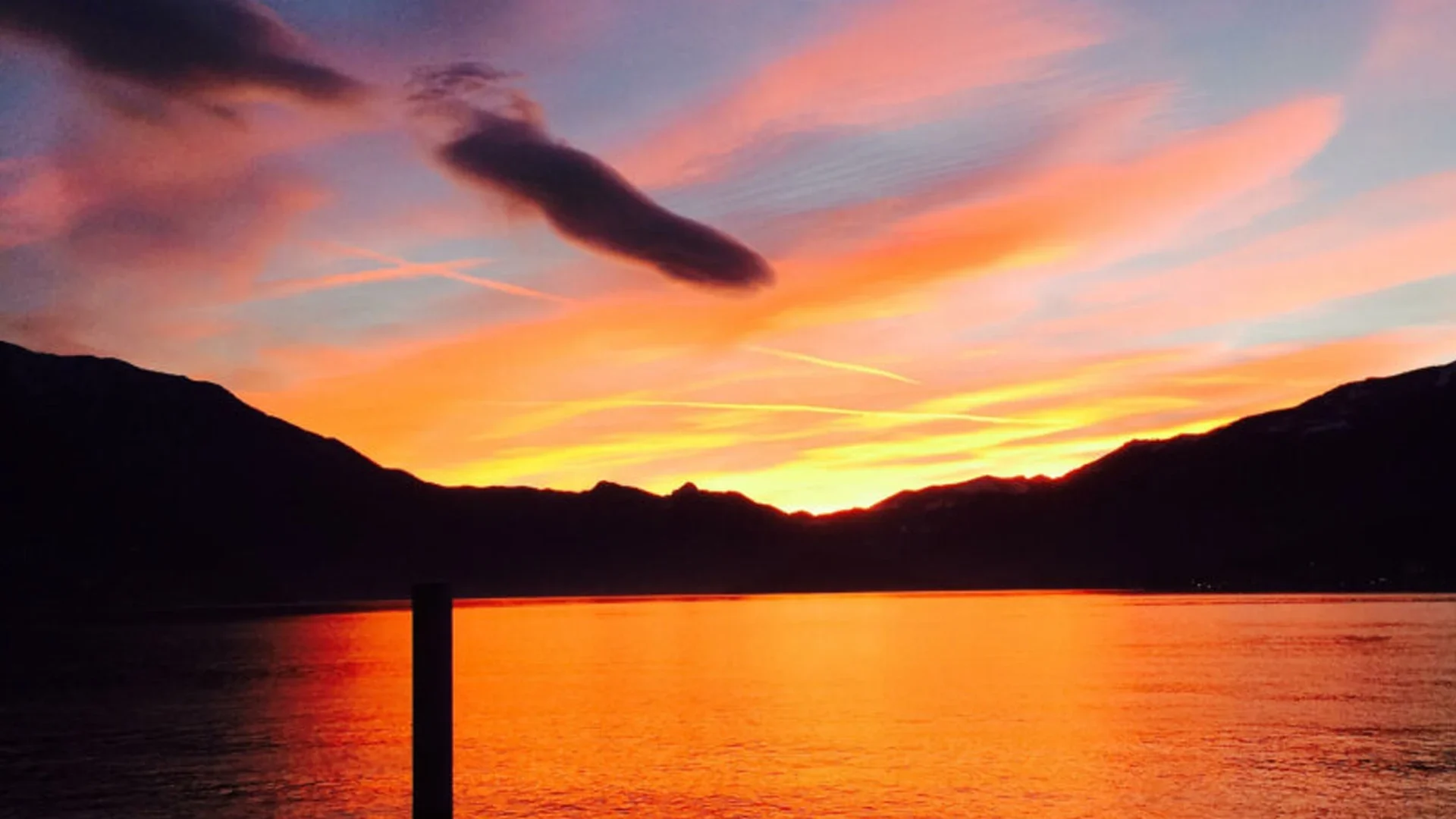 Sanfte Pastellfarben über dem Comer See während einer Bootsfahrt bei Sonnenuntergang